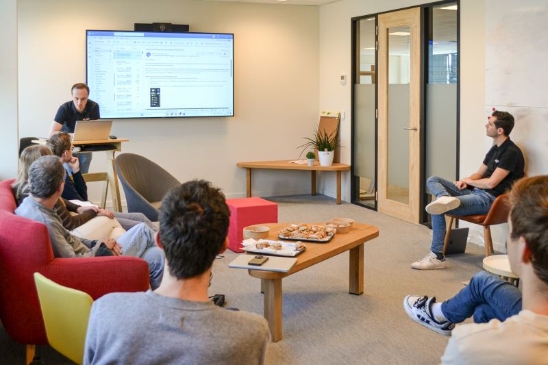 Mensen vergaderen samen in een vergaderzaal met een scherm.